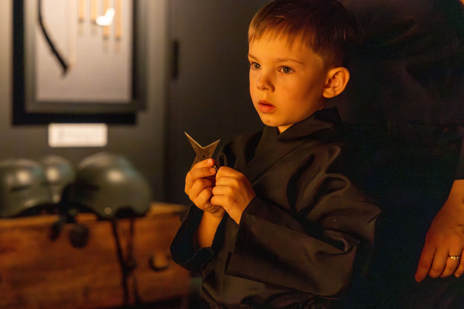 Boy in ninja costume holding a shuriken, totally focused