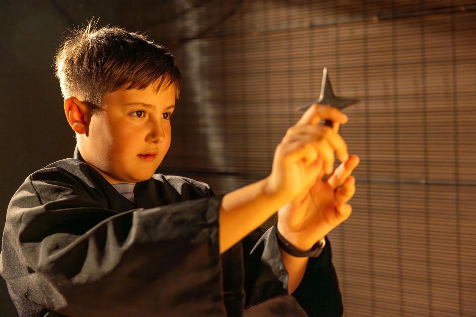 Young child in ninja costume holding a shuriken