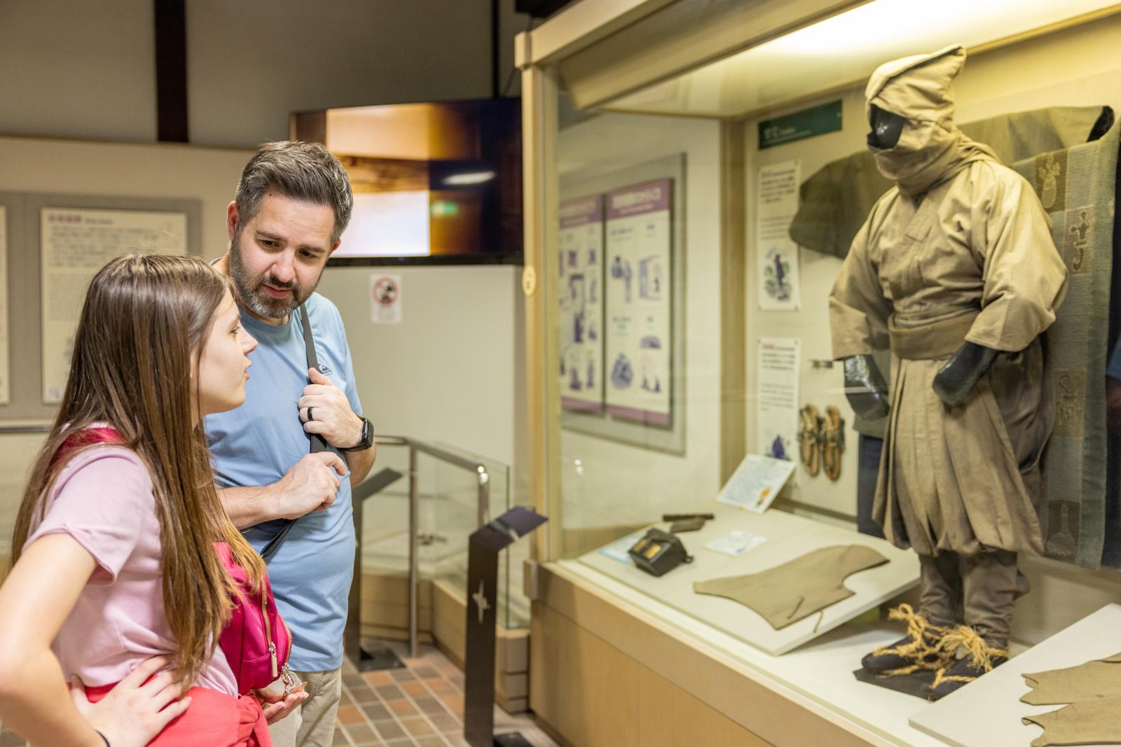 Father and daughter examining a ninja costume display