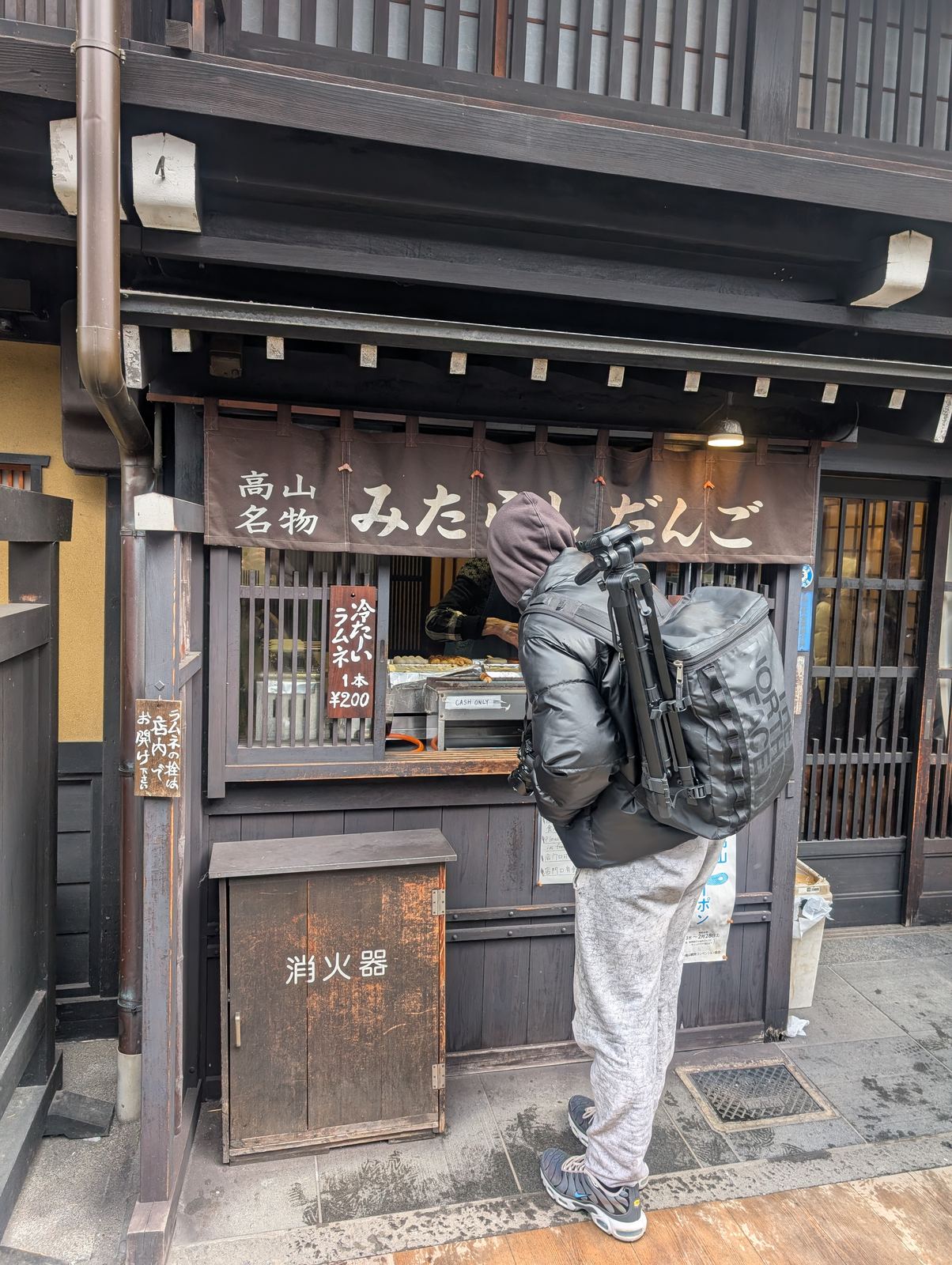 Guest ordering mitarashi dango at a Takayama shop