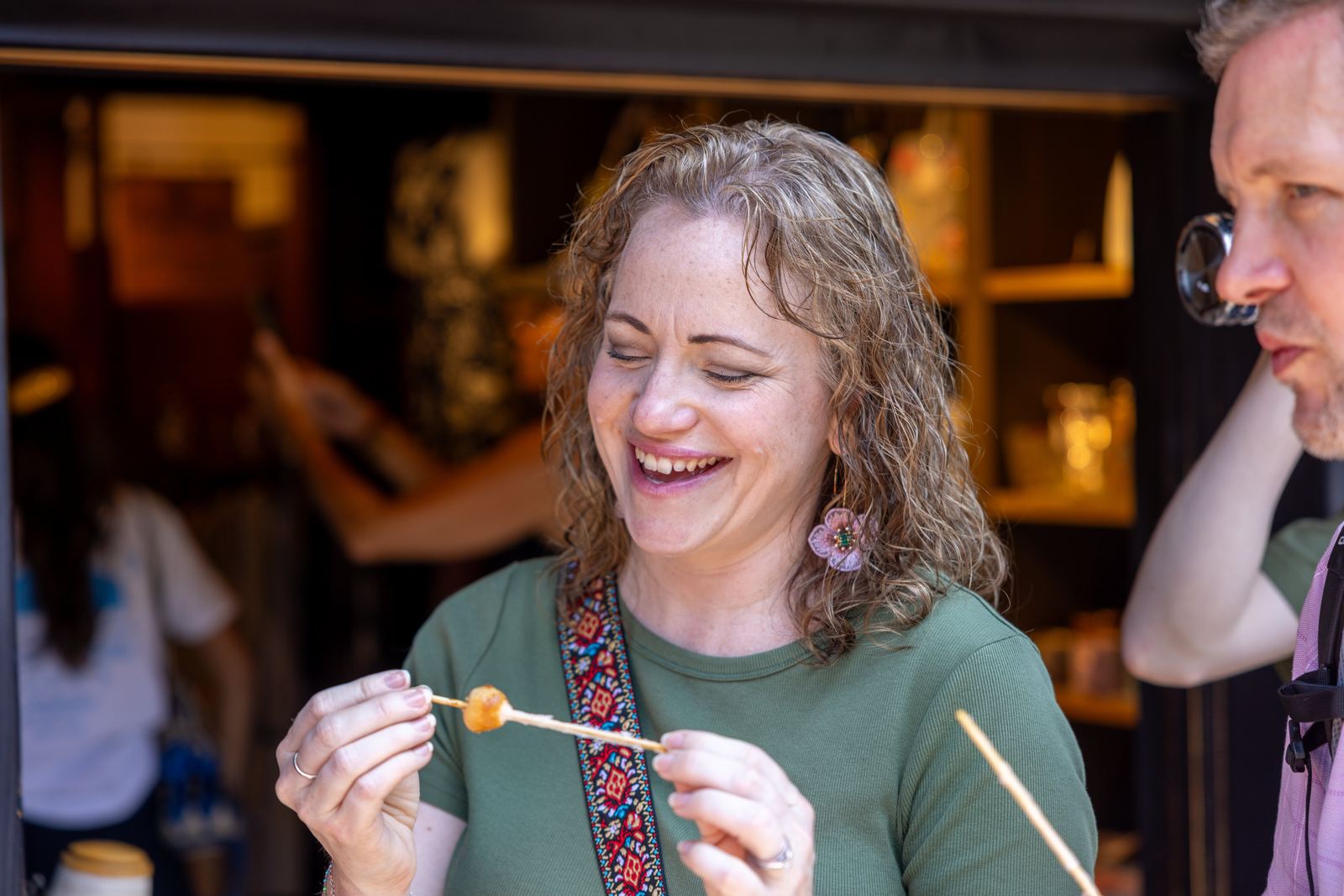 Guest laughing while tasting local street food in Takayama