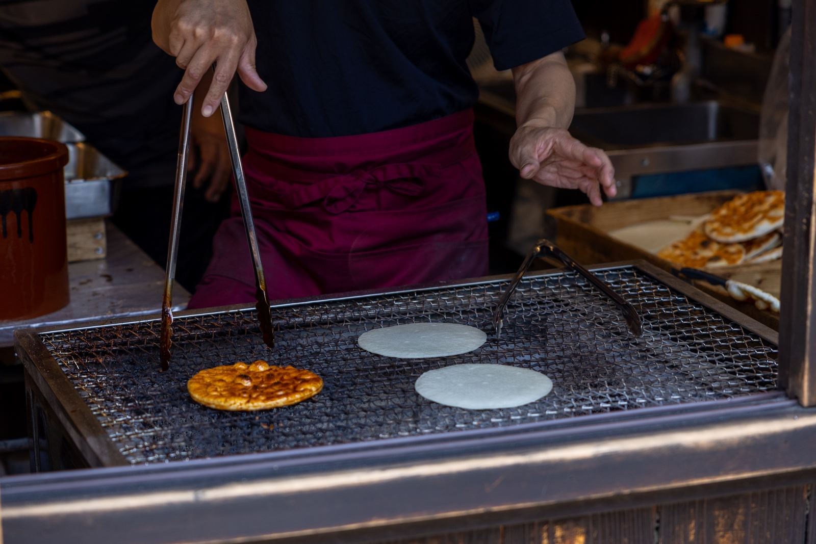 Senbei being grilled on a charcoal grill in Takayama
