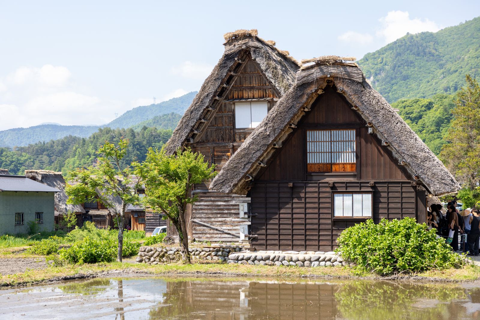 Close-up of a gassho-zukuri farmhouse with mountains behind